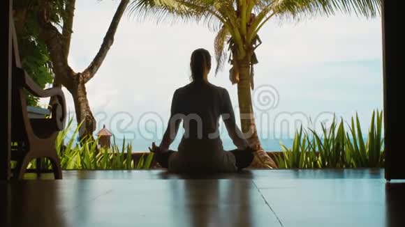 女人的剪影正在练习瑜伽在海边的莲花位置放松美丽的景色自然的声音近距离视频的预览图