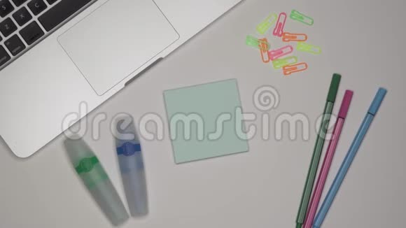 女人在粘粘的记事本上写一份工作特写桌上的笔记本电脑视频的预览图