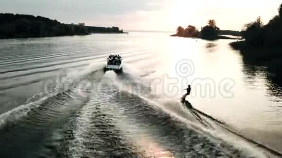 直升机跟着尾板冲浪在阳光下在河上醒来的鸟瞰图视频的预览图
