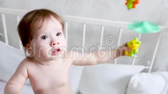 小孩子站在婴儿床上玩玩具视频的预览图