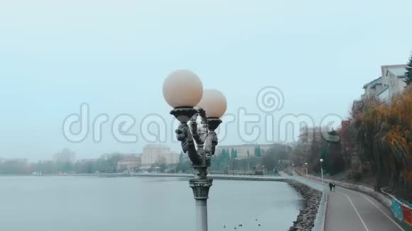 空中飞行在雾天湖附近的路灯周围飞行乌克兰Ternopil视频的预览图