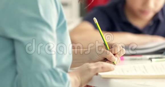 可爱的亚洲青少年男孩做你的家庭作业看着一个相机与微笑的脸在家里视频的预览图