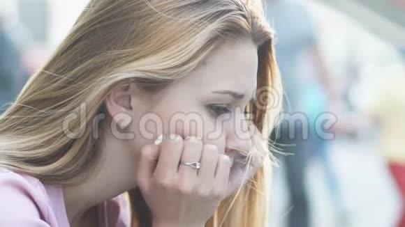 悲伤的女人坐在街上厌倦了日常的节奏紧张的生活在大都市里视频的预览图