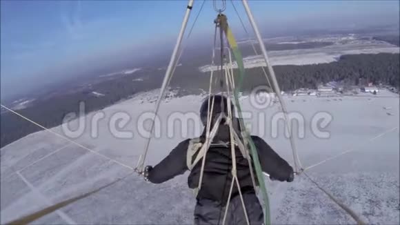 空中滑翔机在阳光明媚的天空中飞过白雪覆盖的草地视频的预览图