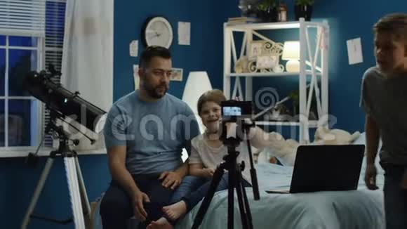带着孩子在家拍视频的男人视频的预览图