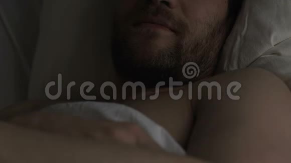 健康满意的男人躺在床上想着他的女朋友微笑着视频的预览图