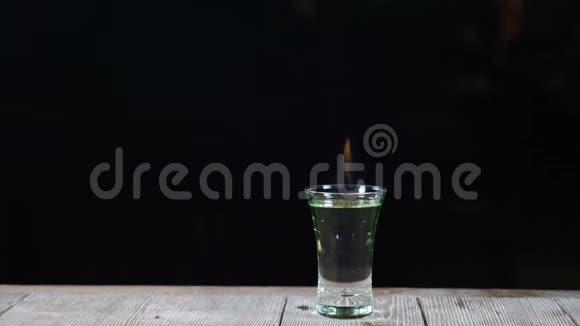 美丽的慢镜头咖啡师在酒吧做鸡尾酒从一杯酒精饮料中燃烧起来的火焰视频的预览图