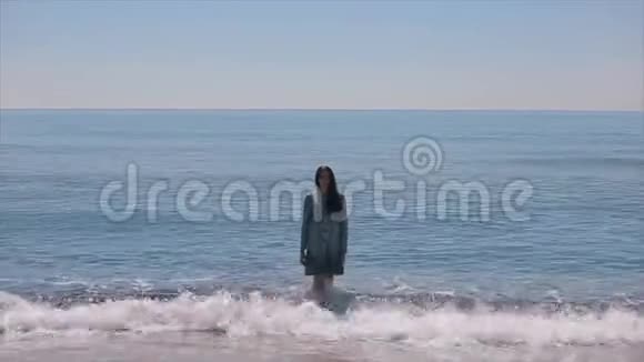 一个穿着湿衣服的漂亮女孩走出波浪状的大海走向照相机视频的预览图
