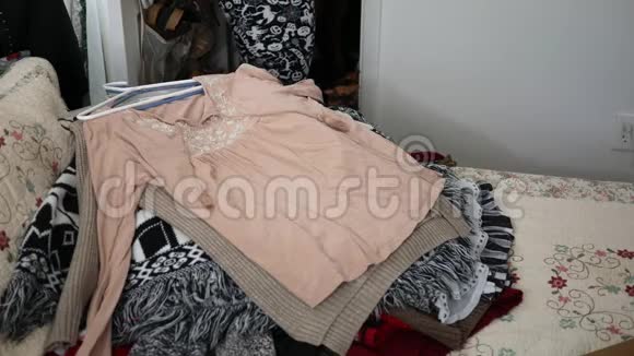 一个女人把她想捐给慈善机构的衣服堆在床上视频的预览图