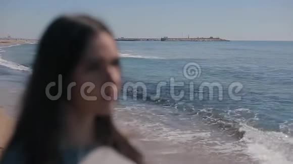 海岸上一个女孩模糊的近景那个女人戴上太阳镜变得目光纯净视频的预览图