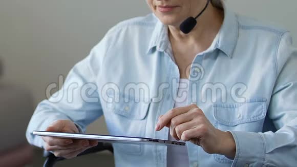 女性在家做自由职业顾问使用平板电脑和耳机麦克风视频的预览图