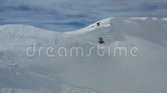 在一个阳光明媚的4k天带着大量雪的高山上令人惊叹的高角度镜头视频的预览图