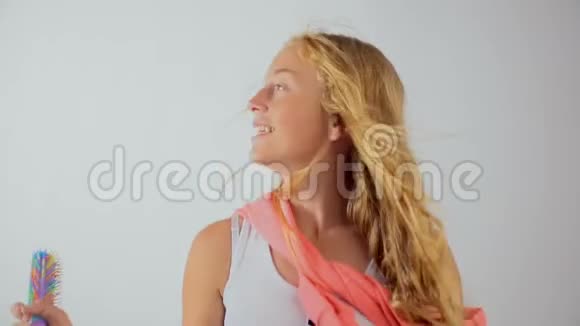 快乐迷人的少女唱着歌拿着梳子像麦克风视频的预览图