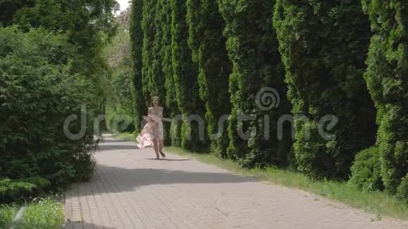 穿着漂亮衣服的白种人有魅力的女人在装饰树木的小巷里奔跑视频的预览图
