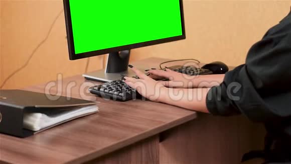 女人在电脑键盘上打字绿色监视器屏幕视频的预览图