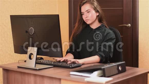在办公室的电脑工作的女人一个穿着黑色衣服的黑钉女孩正在黑色键盘上打字视频的预览图