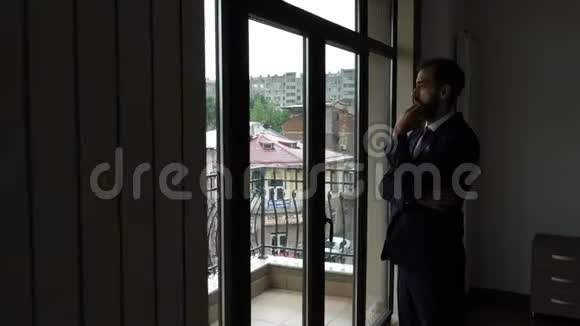 商人站在他门外的窗户前视频的预览图