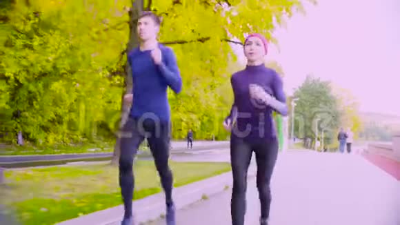 年轻的女人和男人在公园里跑步秋天视频的预览图