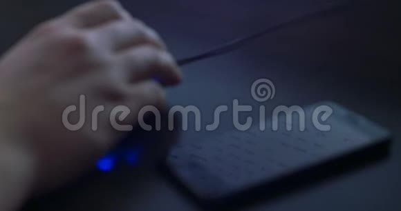 智能手机与滚动页面反射的背景男人在黑暗中用老鼠手关门视频的预览图