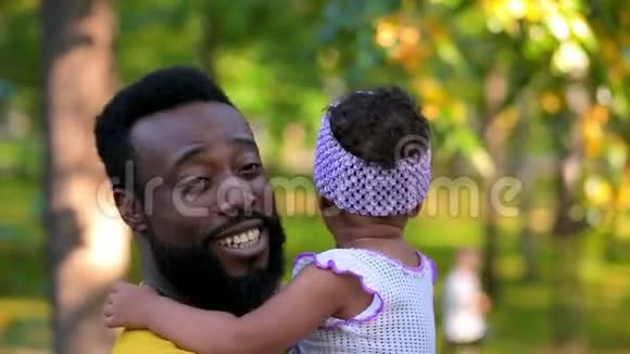 父亲抱着女儿微笑的母亲拍拍女儿视频的预览图