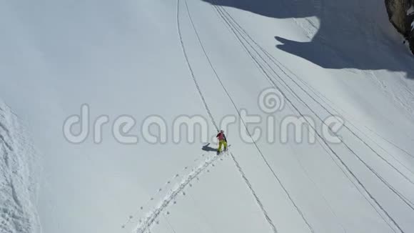 一名男子在滑雪板上攀登一座陡峭的大山空中拍摄的画面是4k视频的预览图