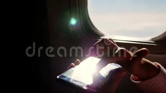 特写镜头太阳光线反射在手机上儿童手和手机面对飞机的黑暗轮廓视频的预览图