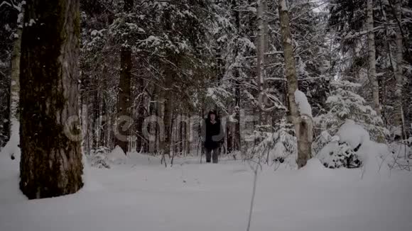 在冬天徒步穿越白雪皑皑的森林的隐士视频的预览图