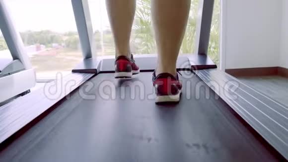 在健身房的跑步机上穿着粉红色的运动鞋把人的腿收起来视频的预览图