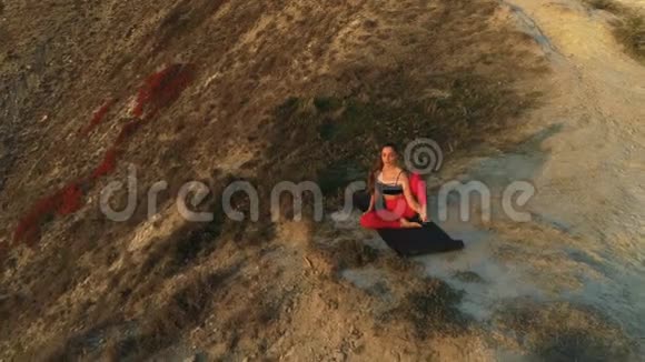 美丽的景色女人做瑜伽伸展在巨大的山上日落边缘视频的预览图