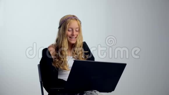 带着笔记本电脑的快乐女孩被隔离在白色背景上视频的预览图