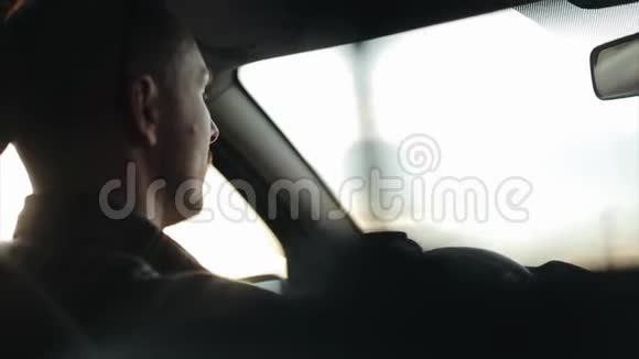 一个戴着太阳镜的成熟男人白天开车后特写镜头视频的预览图