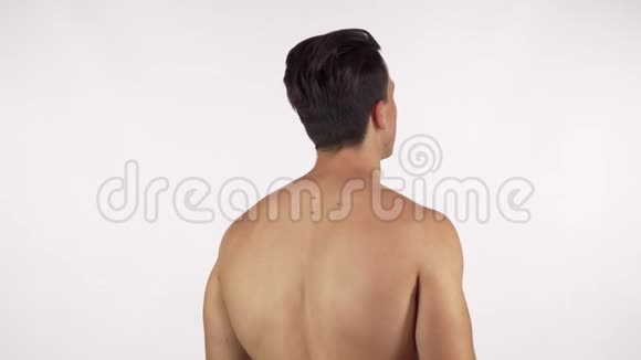 一个肌肉发达的赤膊男子伸展他的背部和手臂肌肉视频的预览图