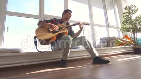 穿衬衫的男人在阳光房弹吉他视频的预览图