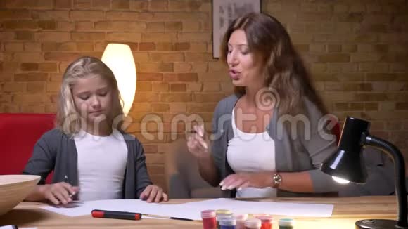 年轻的母亲和漂亮的小女儿的特写镜头他们在一起聊天和消磨时间视频的预览图