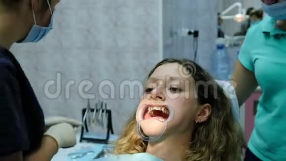 安装金属牙套特写拜访牙医牙齿矫正师从牙齿上取出溶液视频的预览图
