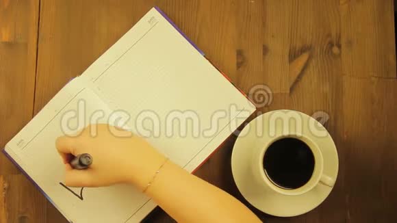 女孩在日记里用黑色的毡尖笔写爱这个词喝咖啡时间跨度视频的预览图