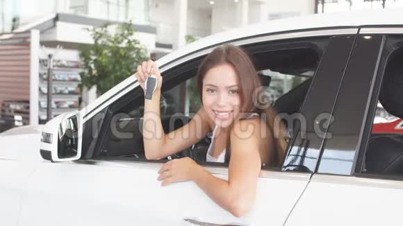 幸福的女司机在车展室的新车里拿着车钥匙视频的预览图
