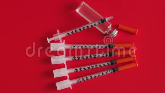 胰岛素注射器和安瓿的胰岛素红色背景特写视频的预览图