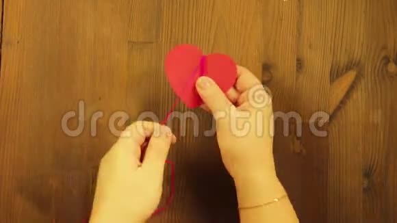 这个女孩用红色的纸板心和粉红色的线做了一件工艺品时间跨度视频的预览图