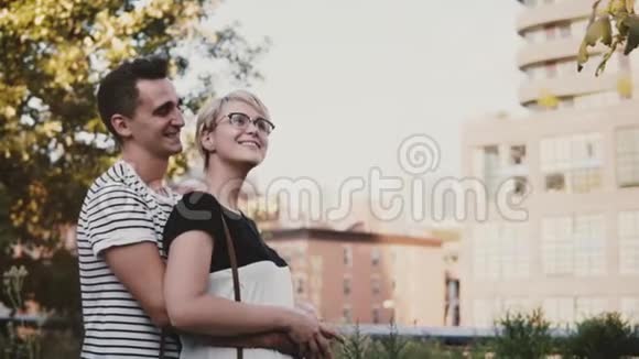 慢动作轻松浪漫的情侣站在一起彼此微笑在一个美丽的公园里交谈视频的预览图