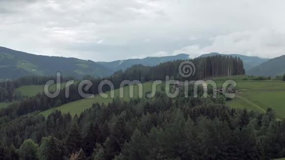 美丽的绿色草原和山上的孤独农场的俯视图视频的预览图