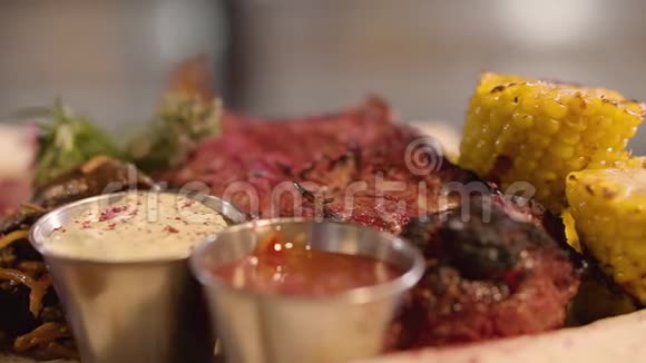 新鲜多汁的肉块有植物美味的肉放在盘子里上面有玉米酱汁和蔬菜服务对象视频的预览图