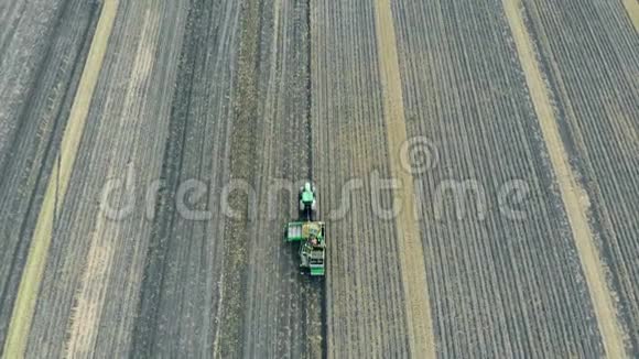 带拖车的绿色拖拉机在田里工作农业拖拉机分拣作物视频的预览图