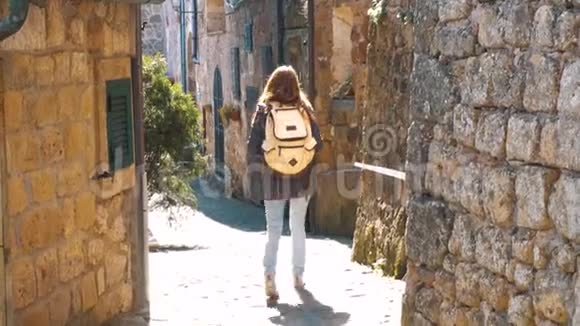 走在意大利乡村狭窄街道上的年轻女性旅行者视频的预览图