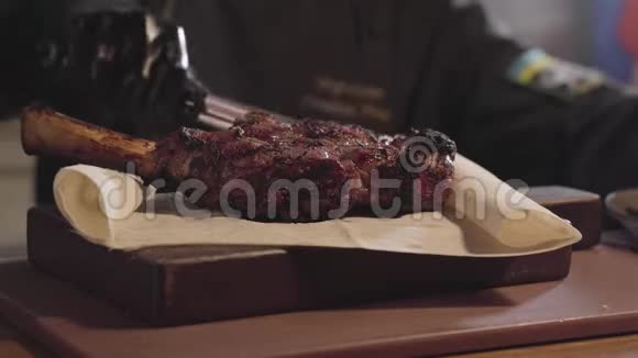 用黑锅手套把厨师关起来放在盘子里的烤肉和烤玉米片上视频的预览图