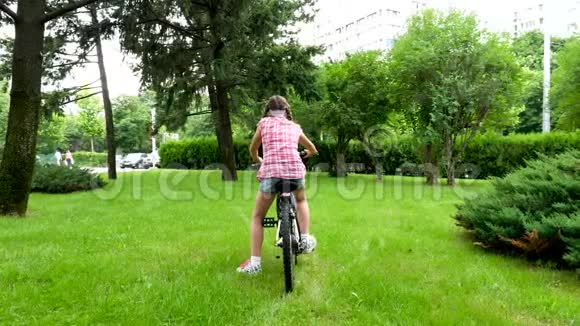 公园里骑自行车的漂亮少女的后景视频的预览图
