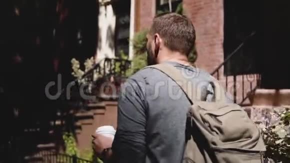 镜头跟随年轻放松的游客背着背包沿着阴凉的夏季纽约街头带着咖啡视频的预览图