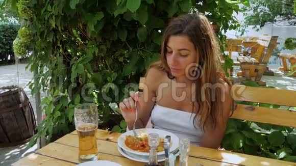 在户外夏季露台上吃饭的晒黑的女人视频的预览图