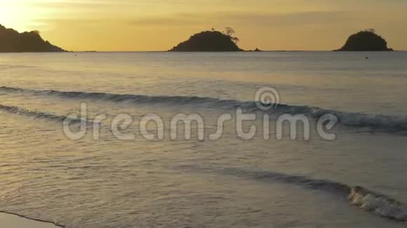 日落时软波在局部海水海滩上冲刷夕阳西下沙滩上海面上一片片平静太阳视频的预览图