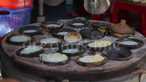 越南街头美食供应商准备的面包罐是一种带有鸡蛋的米饼越南著名的菜肴蛋糕的加工过程从视频的预览图